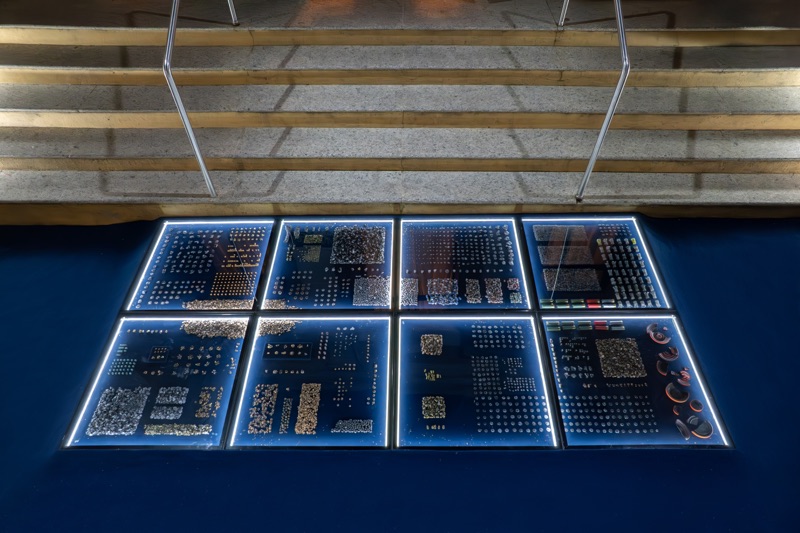 Eight illuminated modules on a blue base, with objects arranged in rows, viewed from above.